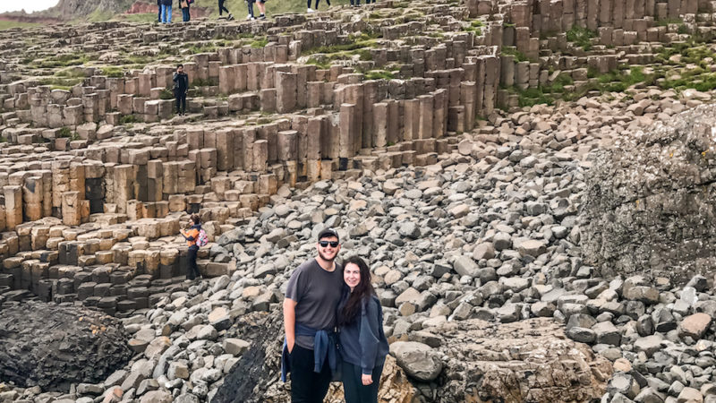 Elaina and Zac standing in front of the columns at Giants Causeway during a Dublin to Giants Causeway Tour in Ireland.