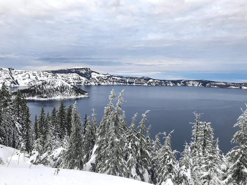 Crater Lake surrounded by snow and snow-covered trees in Oregon