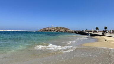 A beach in Naxos Town with Apollo's Temple in the background