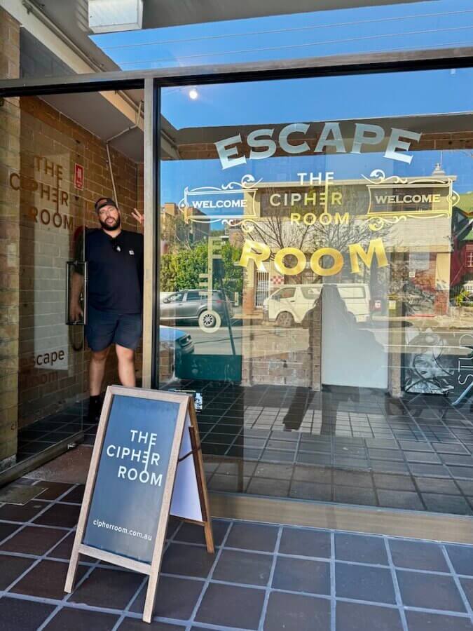 Zac standing in the doorway of Cipher Escape Room St. Peters in Sydney getting ready to play La Rebellion escape room