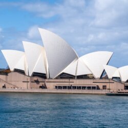 Sydney opera house sitting on the water in the Sydney Harbor