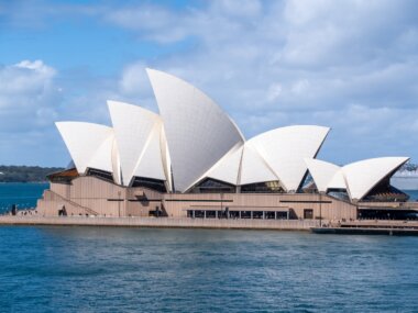 Sydney opera house sitting on the water in the Sydney Harbor