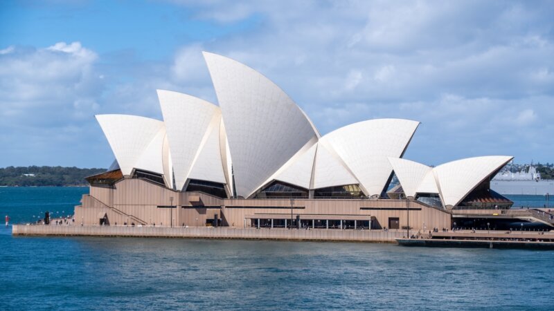 Sydney opera house sitting on the water in the Sydney Harbor