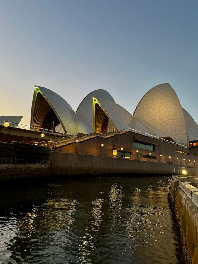 Sydney Opera House lit up at night on the water