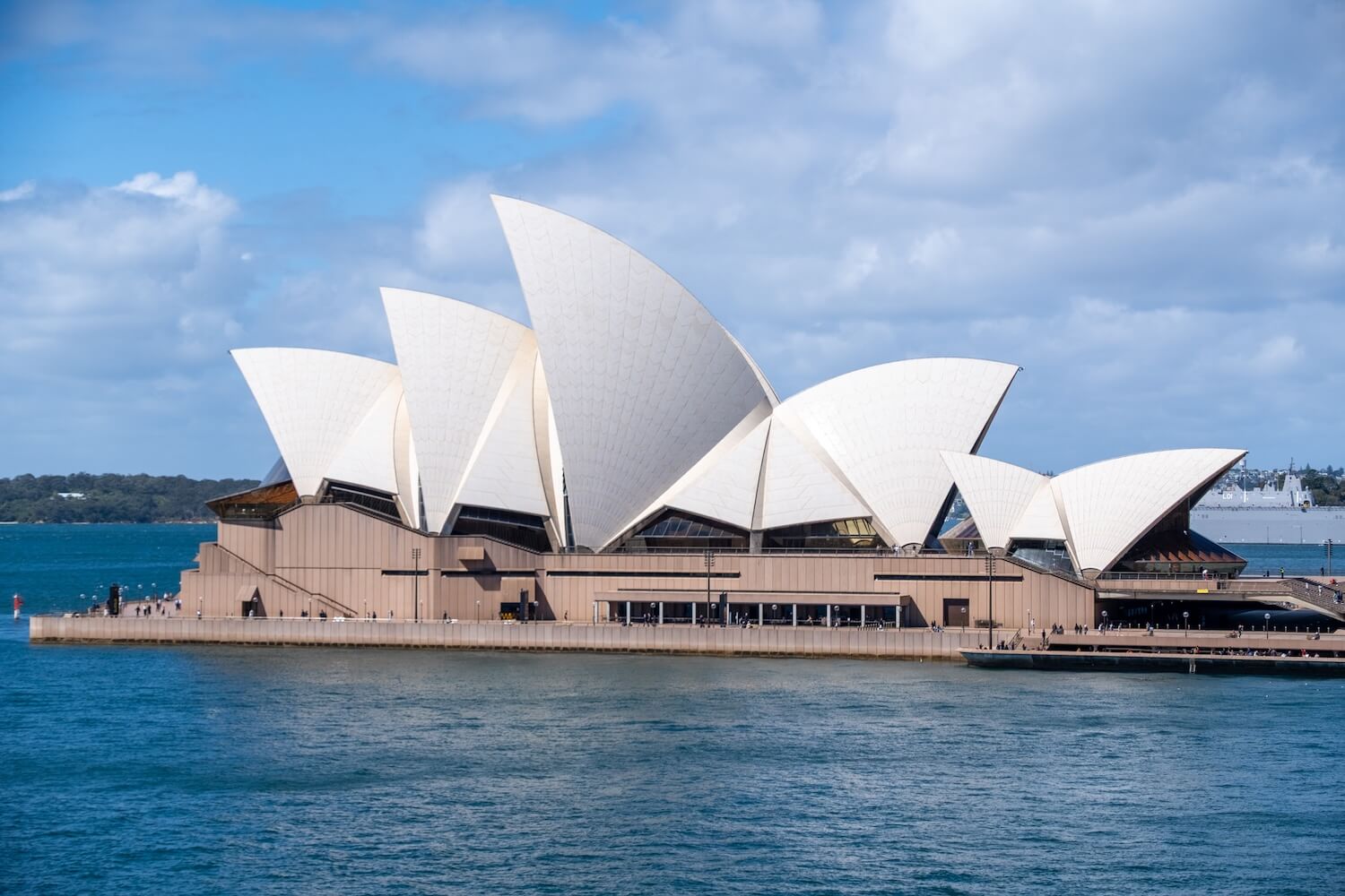 Sydney opera house sitting on the water in the Sydney Harbor